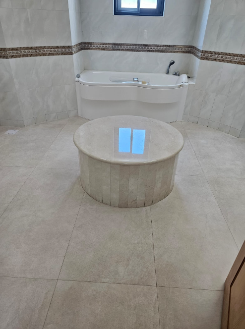Polished stone bathroom floor and circular feature at Flamingo Garden Jasra