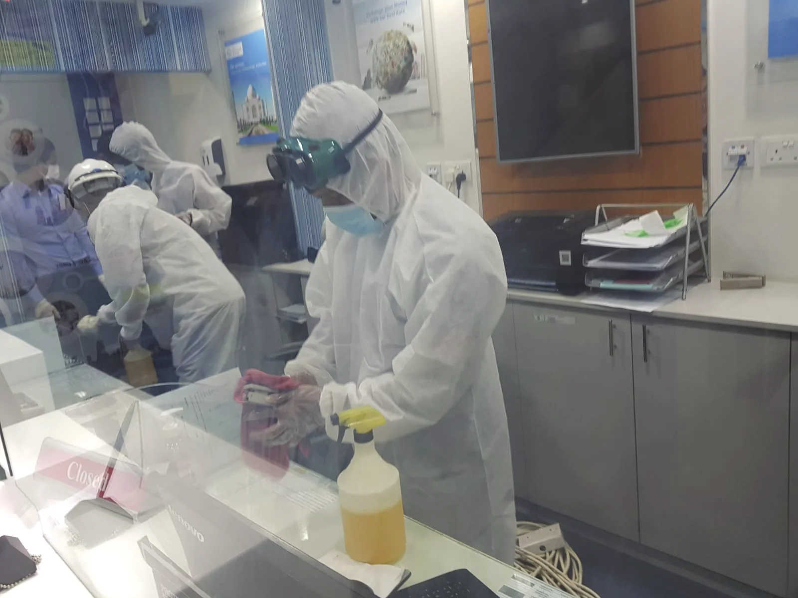 Protective-suit technicians carrying out a disinfection treatment